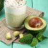 Fresh avocado smoothie on wooden background