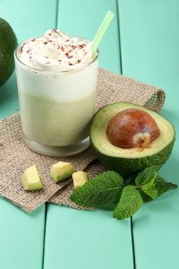 Fresh avocado smoothie on wooden background