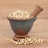 Frankincense in a mortar with pestle over papyrus background.